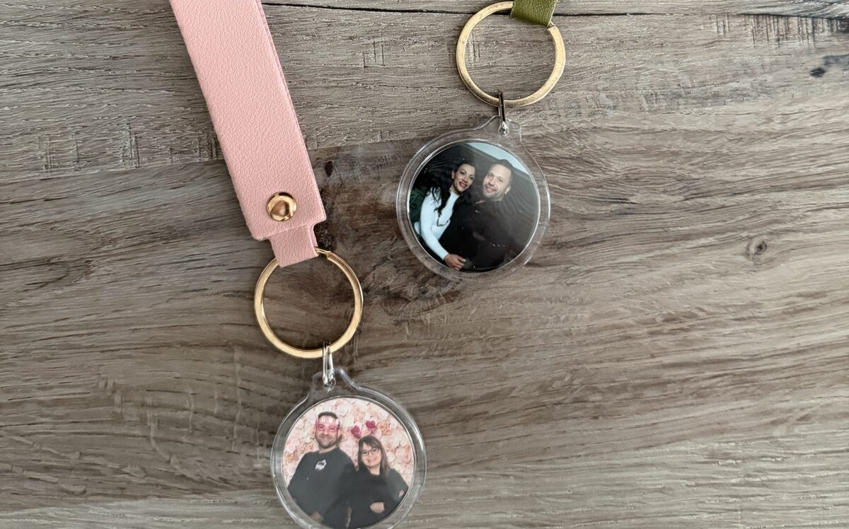 Finished photo keychains displayed on a gold stand at an event